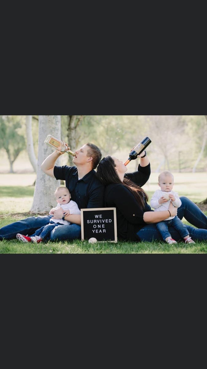 a woman sitting on the ground with two babys drinking from bottles