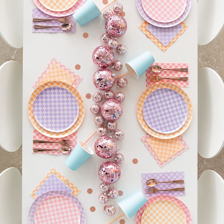 the table is set with plates, napkins and other decorations for a baby's first birthday party