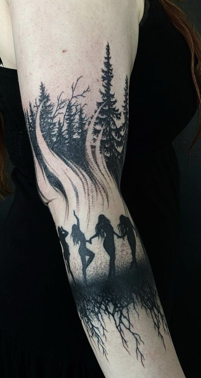 a woman with a tattoo on her arm that has trees and two people holding hands