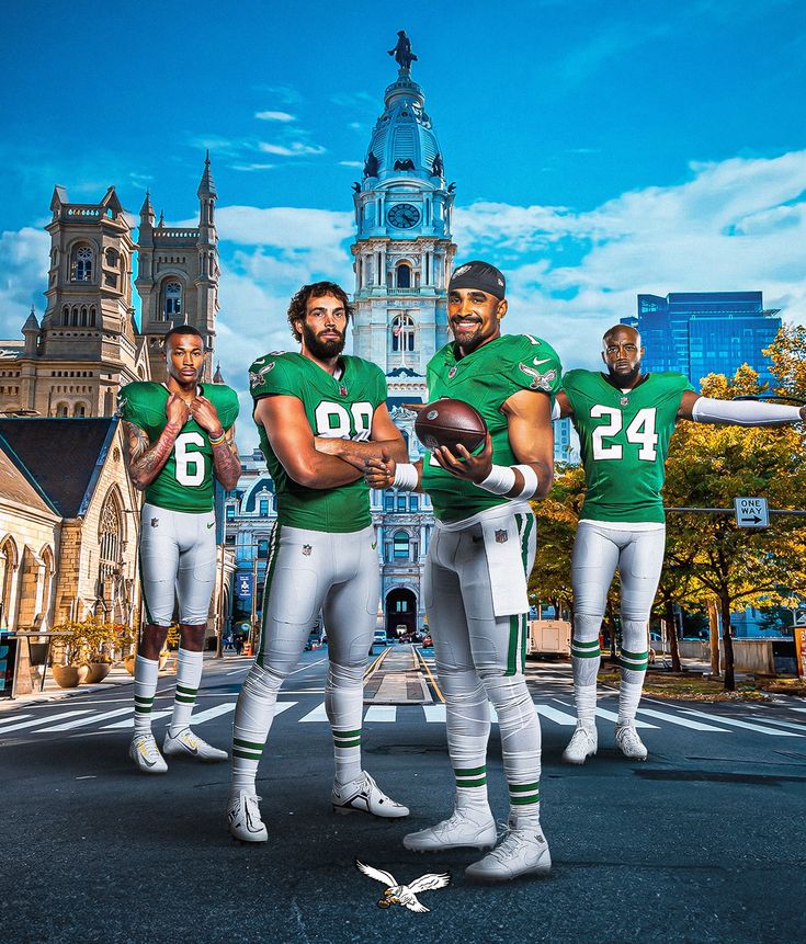 three football players in green and white uniforms are standing on the street with their arms outstretched