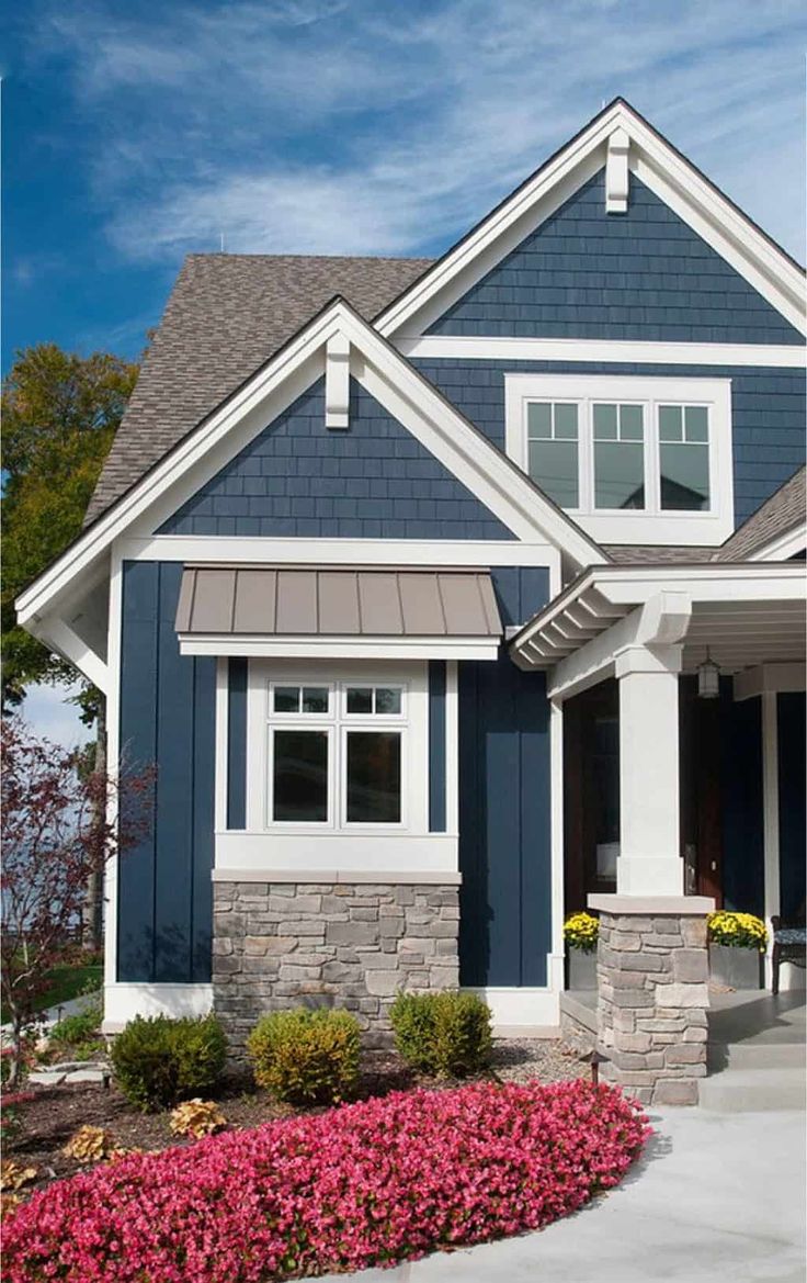 a house with blue siding and white trim on the front door is pictured in this image