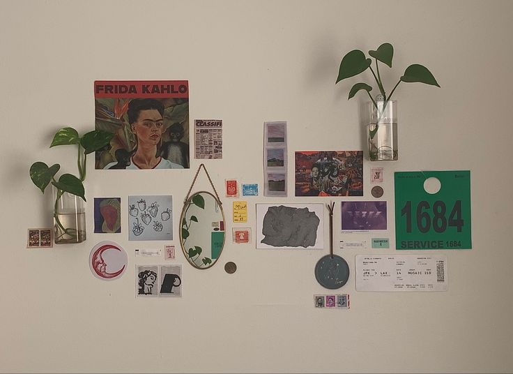 a white wall with various items on it and plants in vases next to them