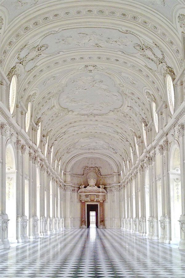 an ornate hallway with white and black checkered flooring is seen in this image