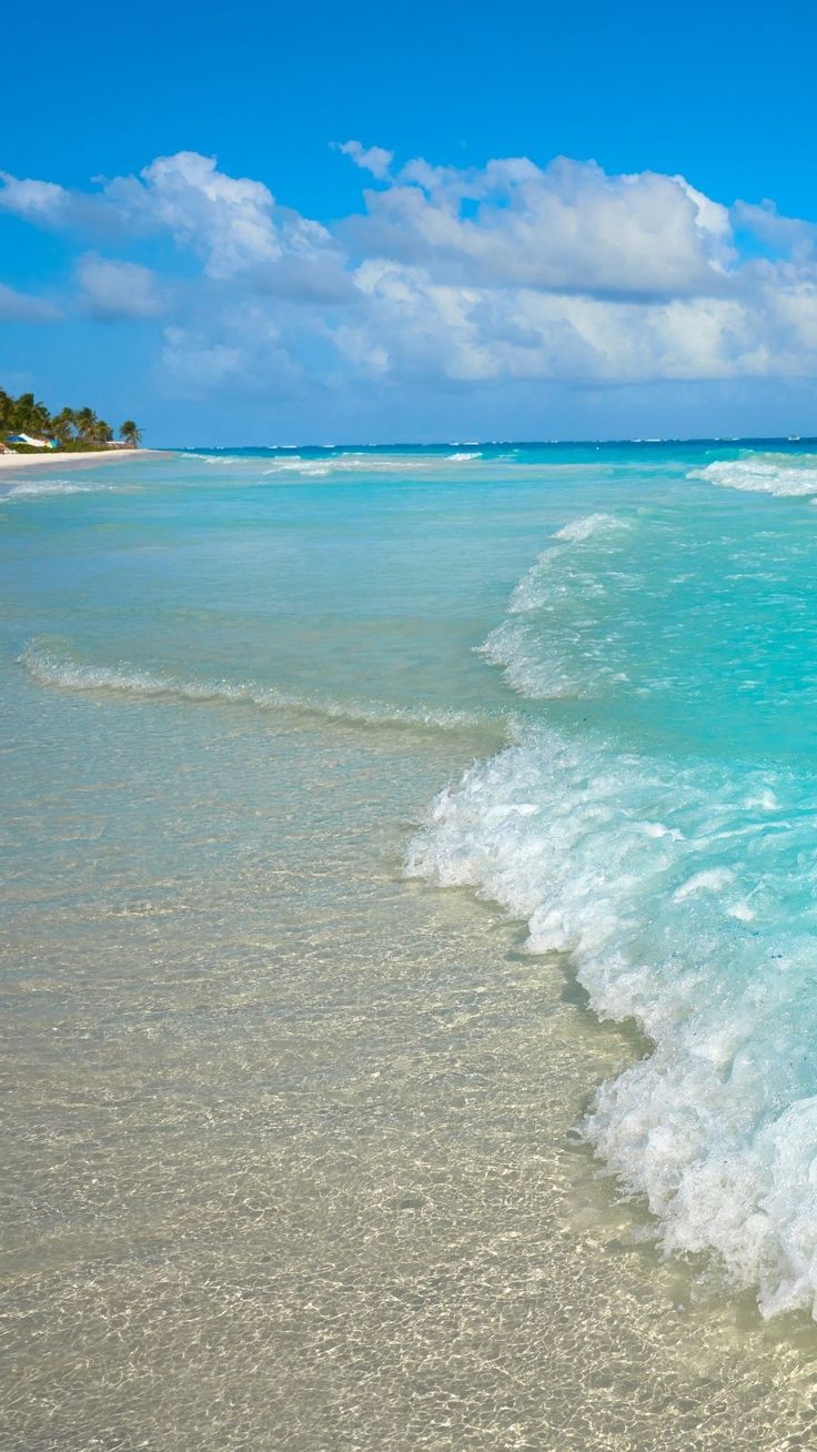 the ocean is blue and white with waves coming in from the shore on a sunny day