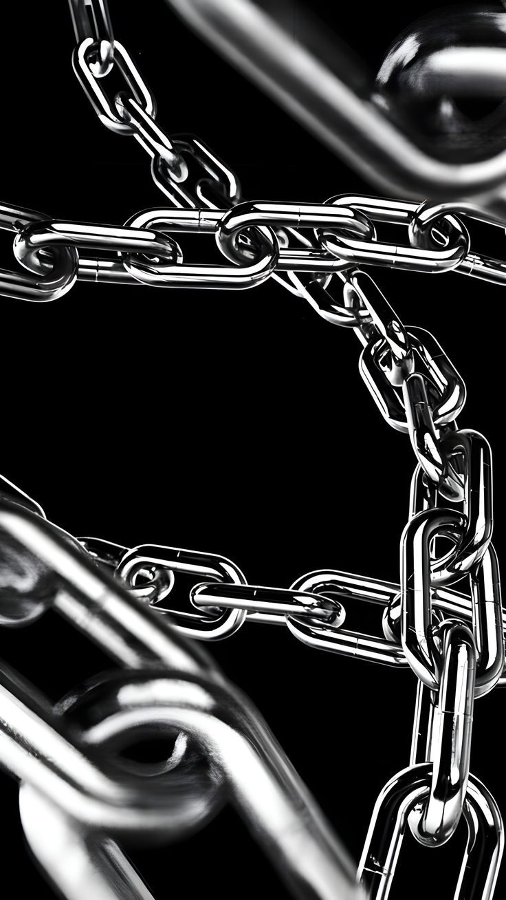 black and white photograph of chains with links attached to each other on a black background