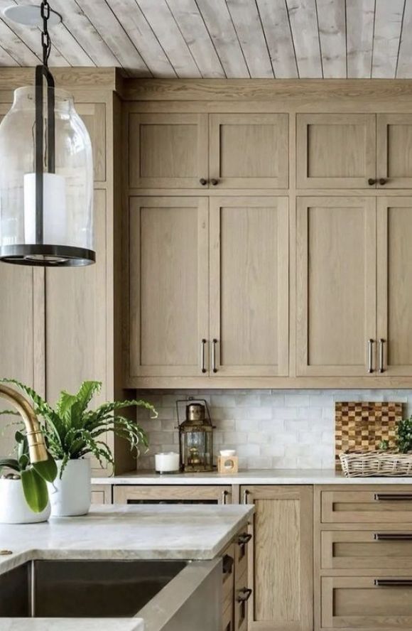 a kitchen filled with lots of wooden cabinets and white counter tops next to a sink