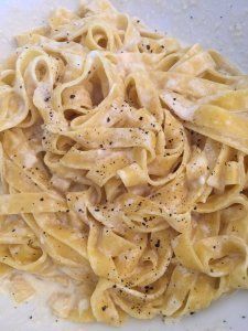 a white plate topped with pasta covered in sauce and seasoning on top of it