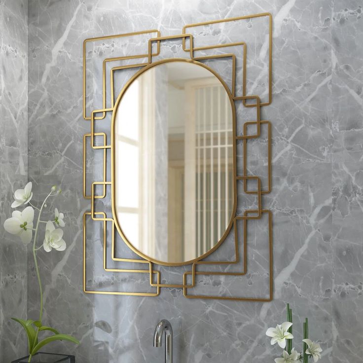 a bathroom sink with a mirror above it and flowers in vases on the counter