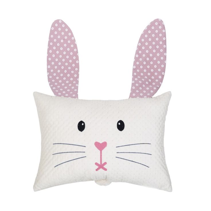 a white pillow with pink ears and polka dots