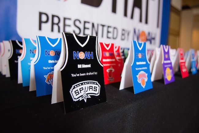 a table topped with different colored basketball jerseys on display in front of a sign that says no one presented by night