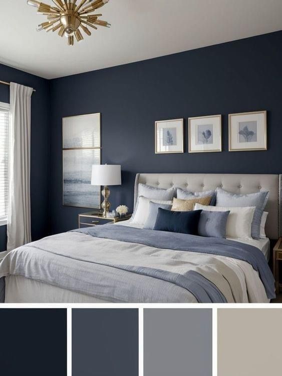 a bedroom with dark blue walls and white bedding, gray curtains, gold chandelier