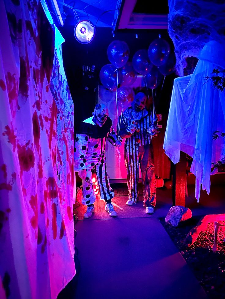 there are balloons and decorations in the room with purple lights on them, as well as zebra - print curtains