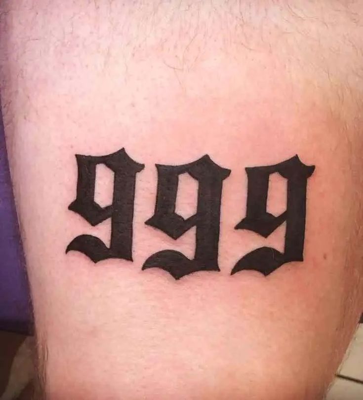 a tattoo on the leg of a man with three letters in black and grey ink