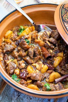 a close up of a bowl of food with a spoon in it on a table