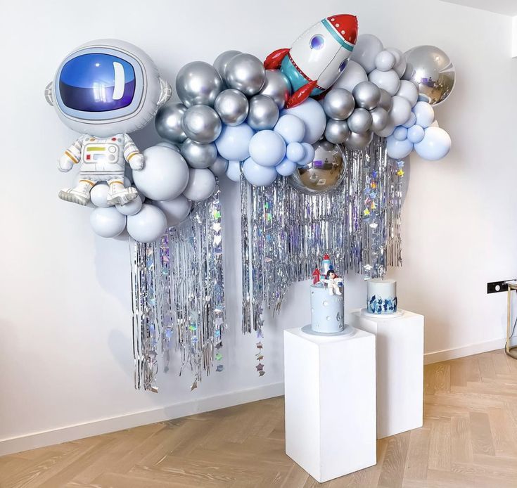 a bunch of balloons that are hanging on the wall in a room with wood flooring