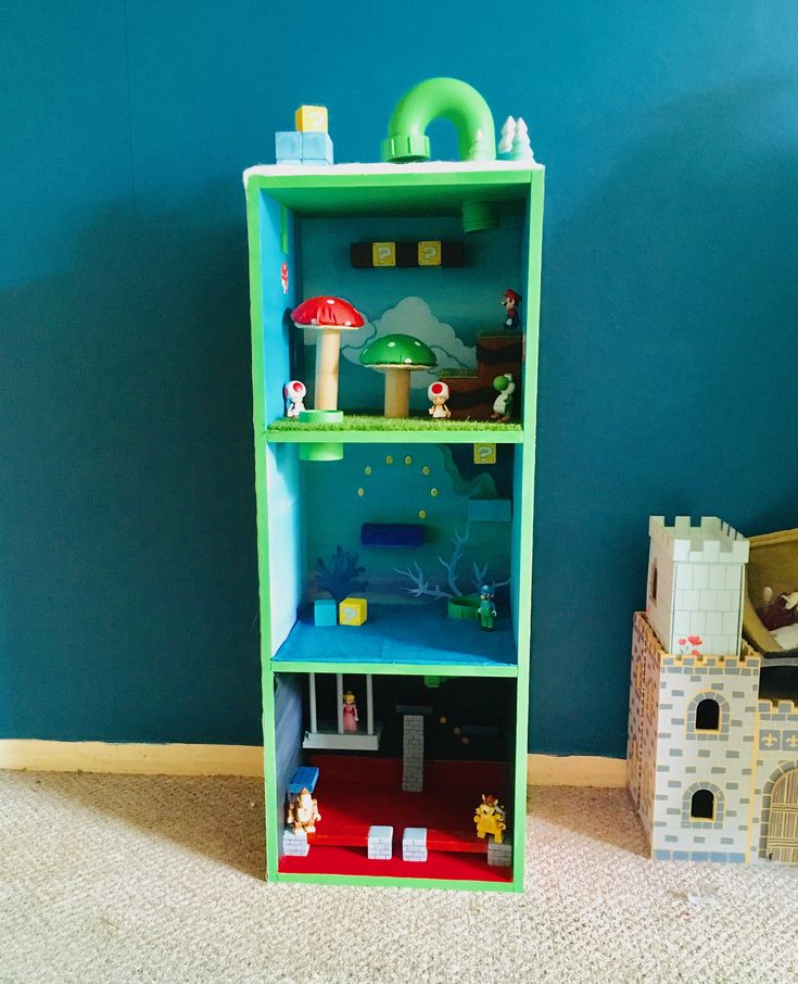 a green shelf with toys on top of it next to a blue wall in a playroom