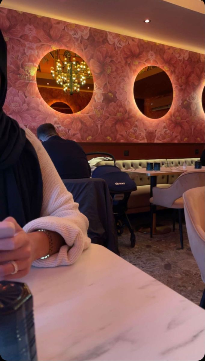 a woman sitting at a table using her cell phone