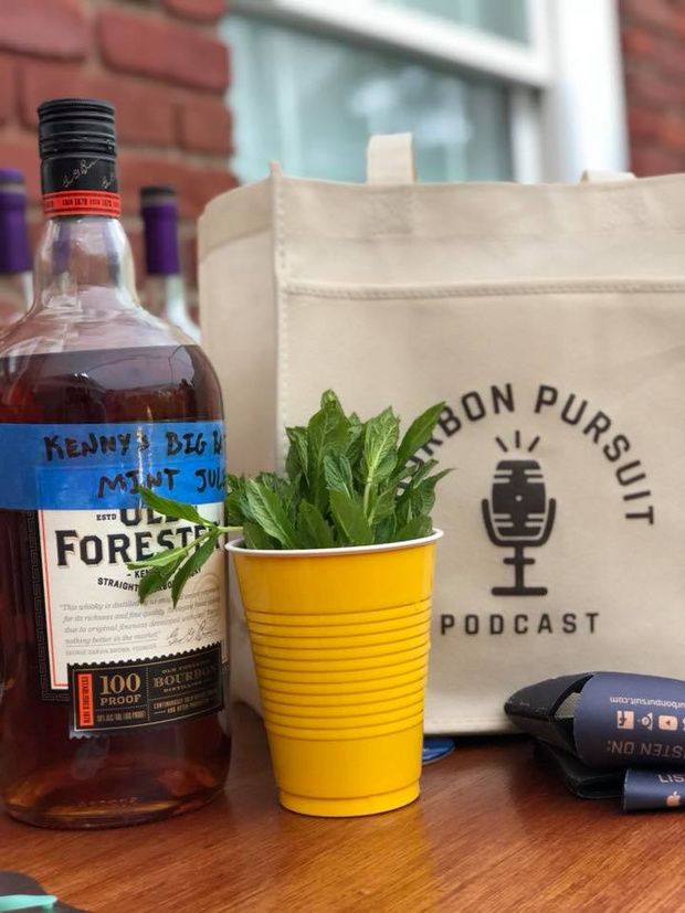 a bottle of alcohol and a potted plant sit on a table next to a pair of scissors