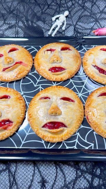 several pies with faces are on a tray