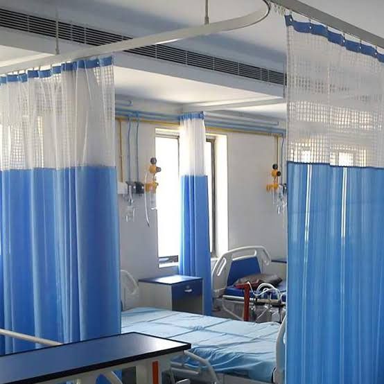 a hospital room with blue and white drapes