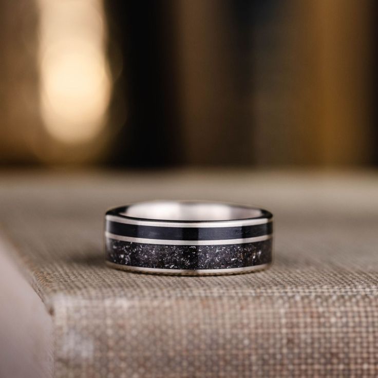 a black and white ring sitting on top of a piece of cloth