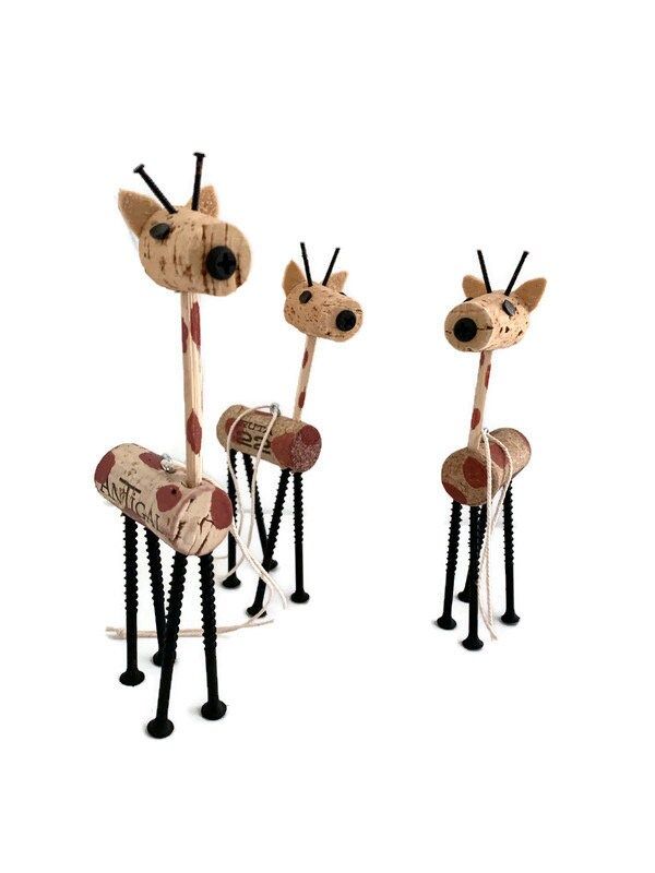 three giraffes made out of wooden sticks and some sort of animal head