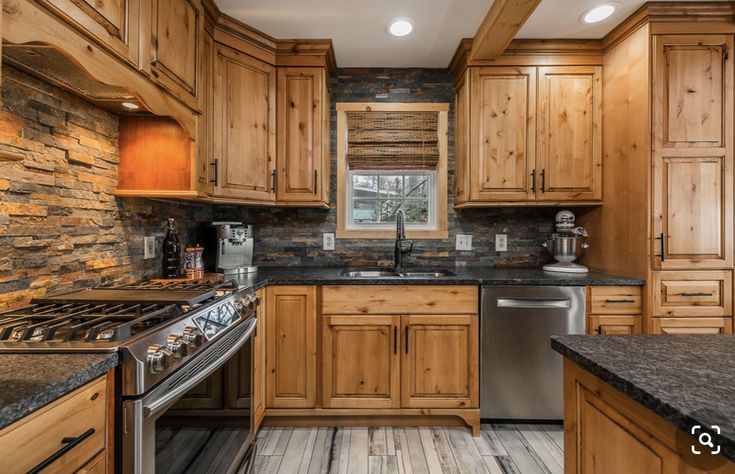 a kitchen with wood cabinets and granite counter tops, stainless steel dishwasher and stove