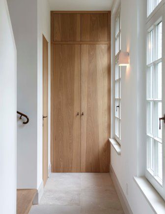 an empty hallway with wooden doors and white walls