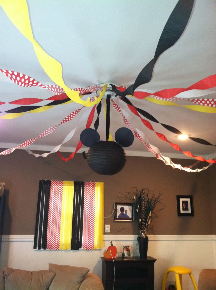 the ceiling is decorated with colorful streamers and mickey mouse ears hanging from it's ceiling