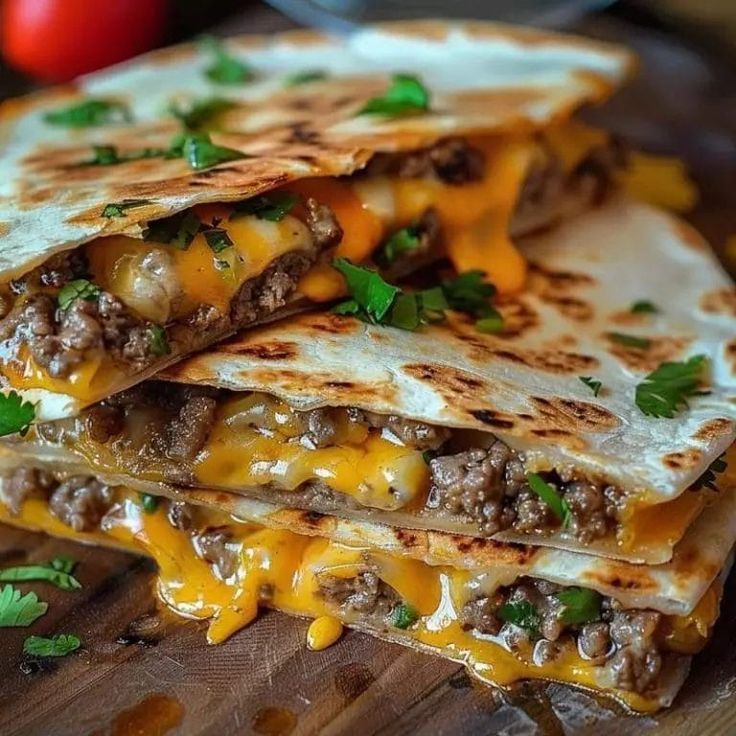 three quesadillas stacked on top of each other with cheese and ground beef