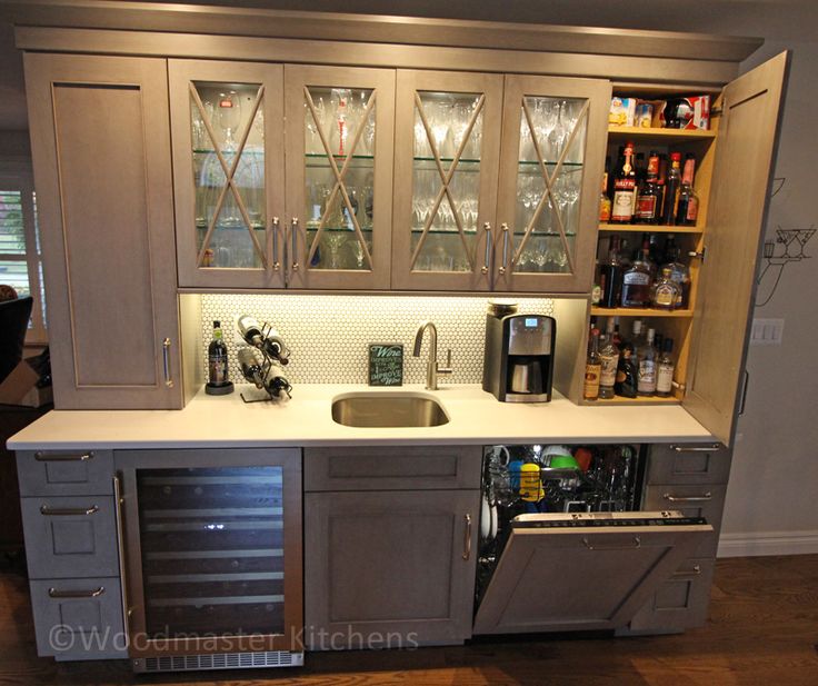 a kitchen with cabinets, sink and wine glass rack in it's cupboards