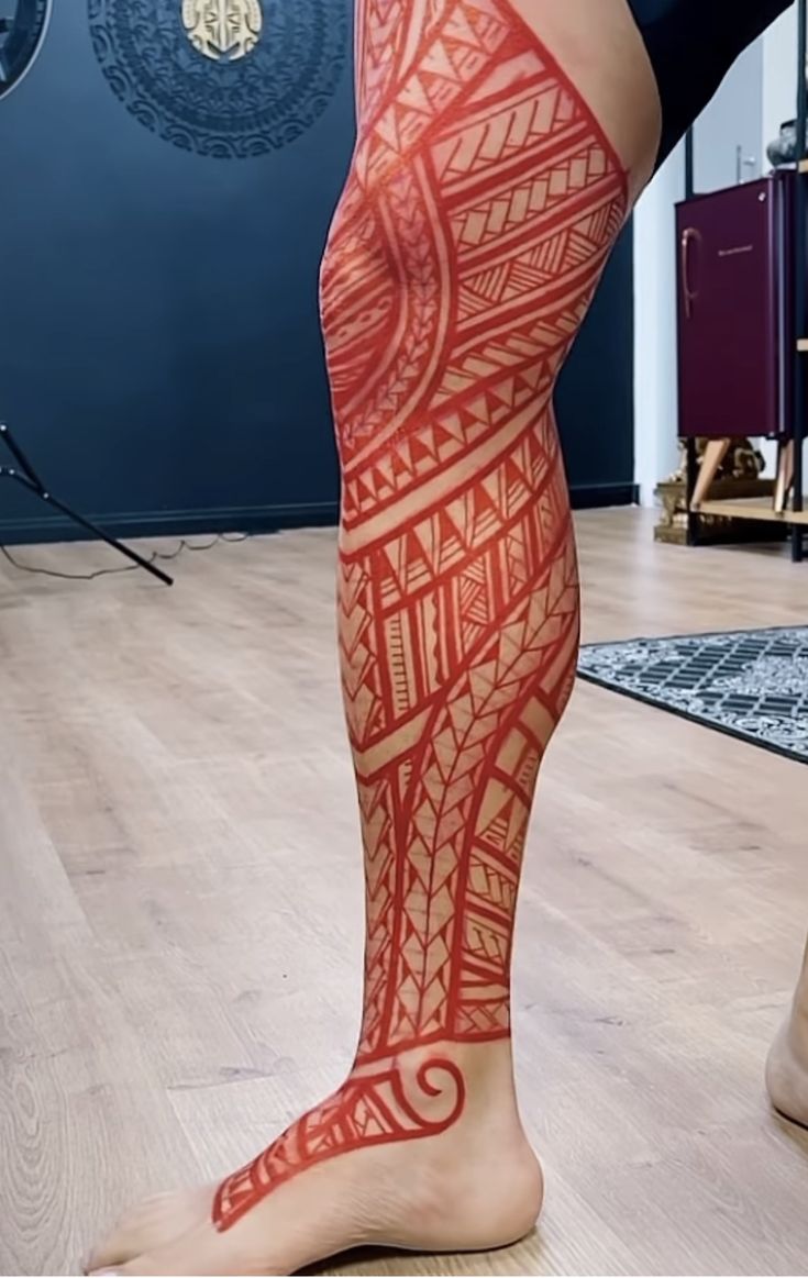 the legs and ankles of a woman with red tattoos