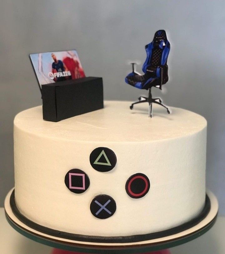 a white cake with black and red designs on it, topped with a gaming controller