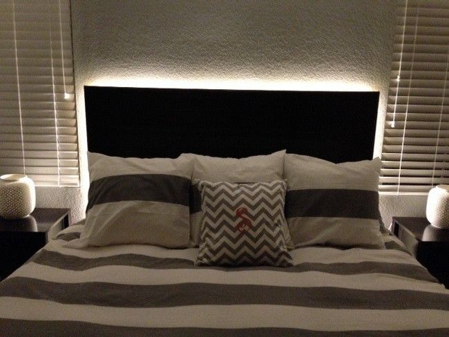 a black and white bed with two pillows on it's headboard next to the night stand