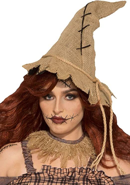 a woman with long red hair wearing a scarecrow hat