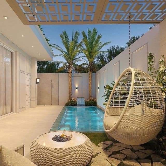 an outdoor living area with a pool and hanging chair