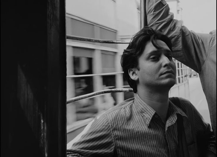 a black and white photo of a man getting his hair combed