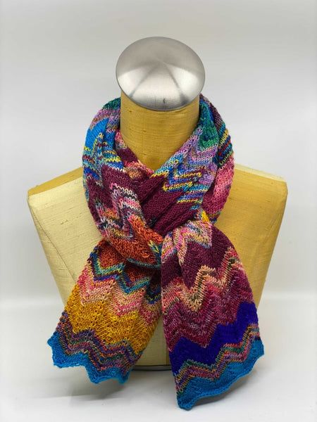 a multicolored knitted scarf on a mannequin