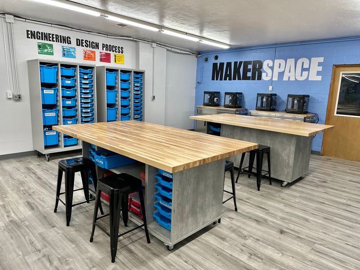 a room filled with lots of wooden tables and blue bins