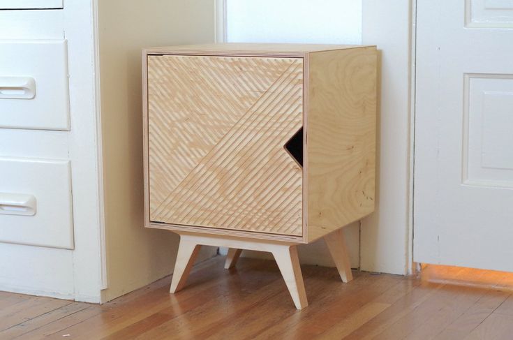 a wooden cabinet sitting on top of a hard wood floor next to a white door