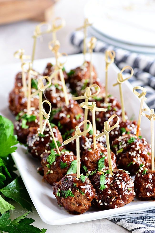 meatballs with toothpicks and garnishes on a white platter