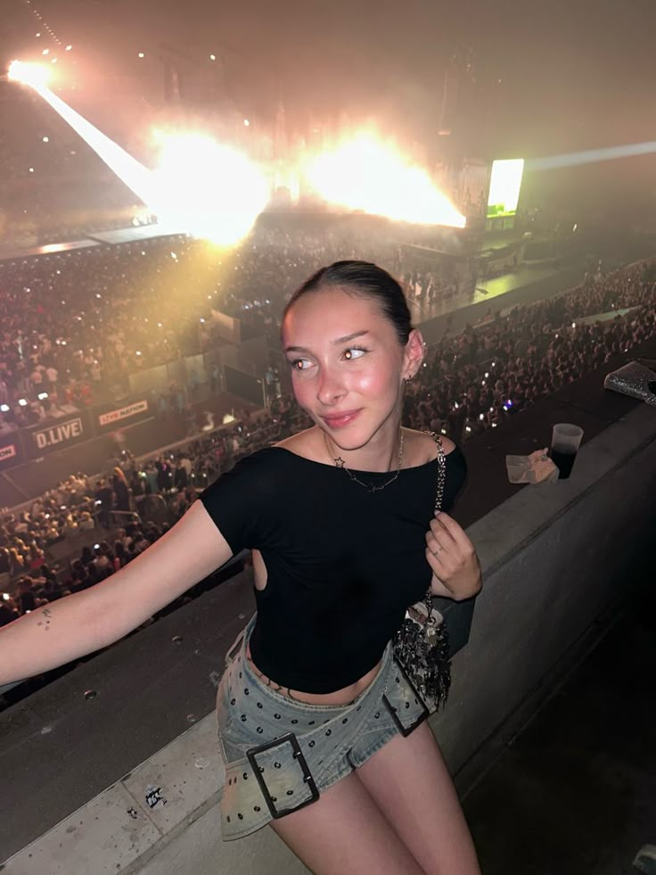 a woman standing in front of a crowd at a concert