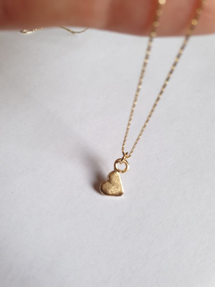 Solid gold necklace, heart necklace, 14k gold necklace, gold pendant necklace, 9k necklace, minimalist necklace, Bat Mitzvah gift This solid gold heart necklace has a beautiful tiny heart pendant, which is attached to a delicate 14k solid gold necklace. The small heart pendant is chicly hung sideways. The heart gold pendant is available both in 9k and 14 karat solid gold and is simply a great valentine's day gift or a perfect Bat mitzvah gift. Dimensions: The necklace is available in multiple le Minimalist 14k Gold-filled Jewelry With Heart Charm, Dainty 14k Gold-filled Yellow Gold Heart Necklace, Dainty 14k Gold-filled Heart Necklace In Yellow Gold, Minimalist 14k Gold Necklace With Heart Charm, Everyday 14k Yellow Gold Filled Heart Necklace, Minimalist Tiny Heart Pendant Necklaces, Dainty Tiny Heart Pendant Necklace, Minimalist Tarnish Resistant 14k Gold Heart Necklace, Minimalist Tiny Heart Pendant Necklace