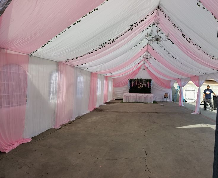 the inside of a pink and white tent with curtains