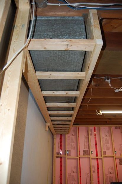 an unfinished room with wooden beams and insulation in the ceiling, along with red tape on the walls