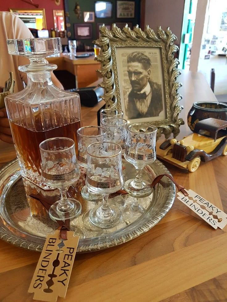 an old fashioned decanter and glasses on a tray with a sign that says whiskey