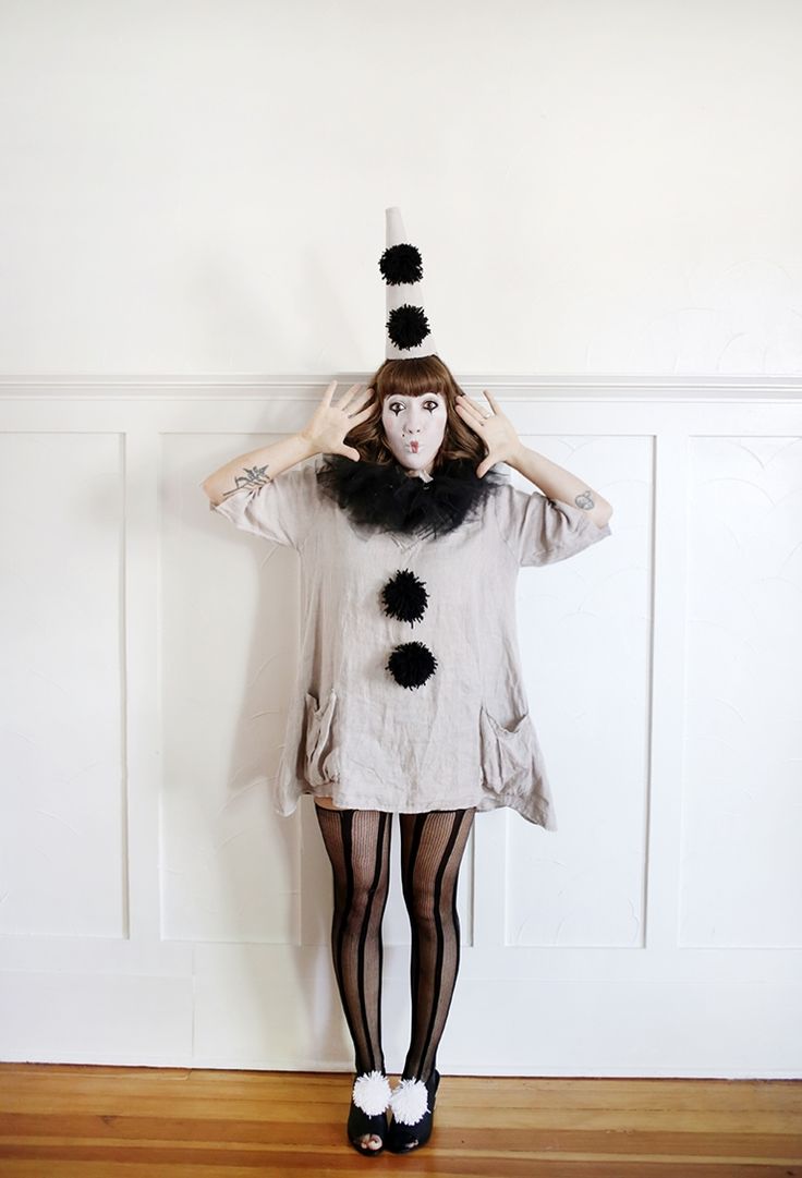 a woman is standing in front of a wall with her hands on her head while wearing tights and stockings