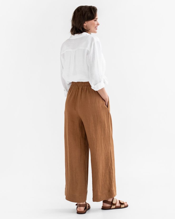 Elevate your style with the ALCUDIA Wide Leg Linen Pants in Cinnamon. These high-rise pants feature a wide leg design and are designed to hit below the ankle with an inseam of 28.5"/72 cm. The pants offer both fashion and functionality with two side seam pockets, providing convenient storage while maintaining a sleek silhouette. The elastic waist ensures a comfortable and flattering fit, making these pants perfect for any occasion.• Wide leg design• 2 side seam pockets for added functionality an Straight Leg Linen Pants For Fall, Fall Linen Pants With Straight Leg, Brown Linen Bottoms For Spring, Casual Wide-leg Flax Pants, Chic Trousers In Flax Color, Brown Linen Bottoms For Work, Brown Linen Wide Leg Pants For Summer, Wide-leg Linen Pants, Relaxed Fit Linen Culottes With Wide Legs