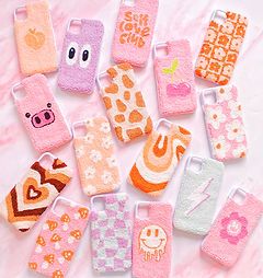 many cell phones are lined up together on a pink tablecloth with white and orange designs