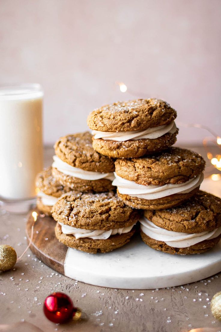 a stack of cookies sitting on top of a white plate next to a glass of milk